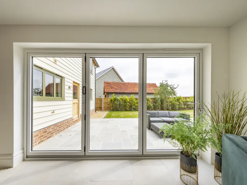 ignal white aluminium bifold doors looking out onto a garden from inside a home