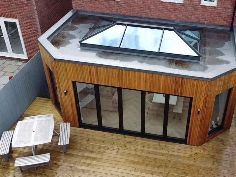 Jet black aluminium bifold doors installed on a North West home with timber cladding